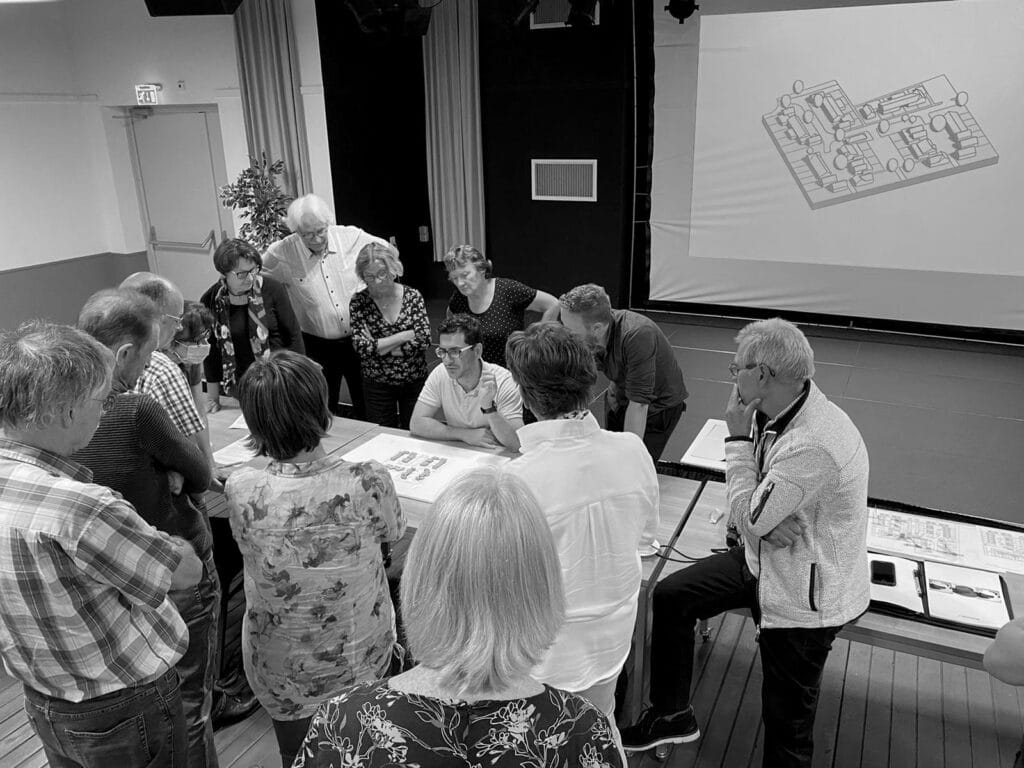 Overleg aan tafel met architecten over stedenbouwkundige situatie (met of zonder daken) in collectief overleg (CPO).