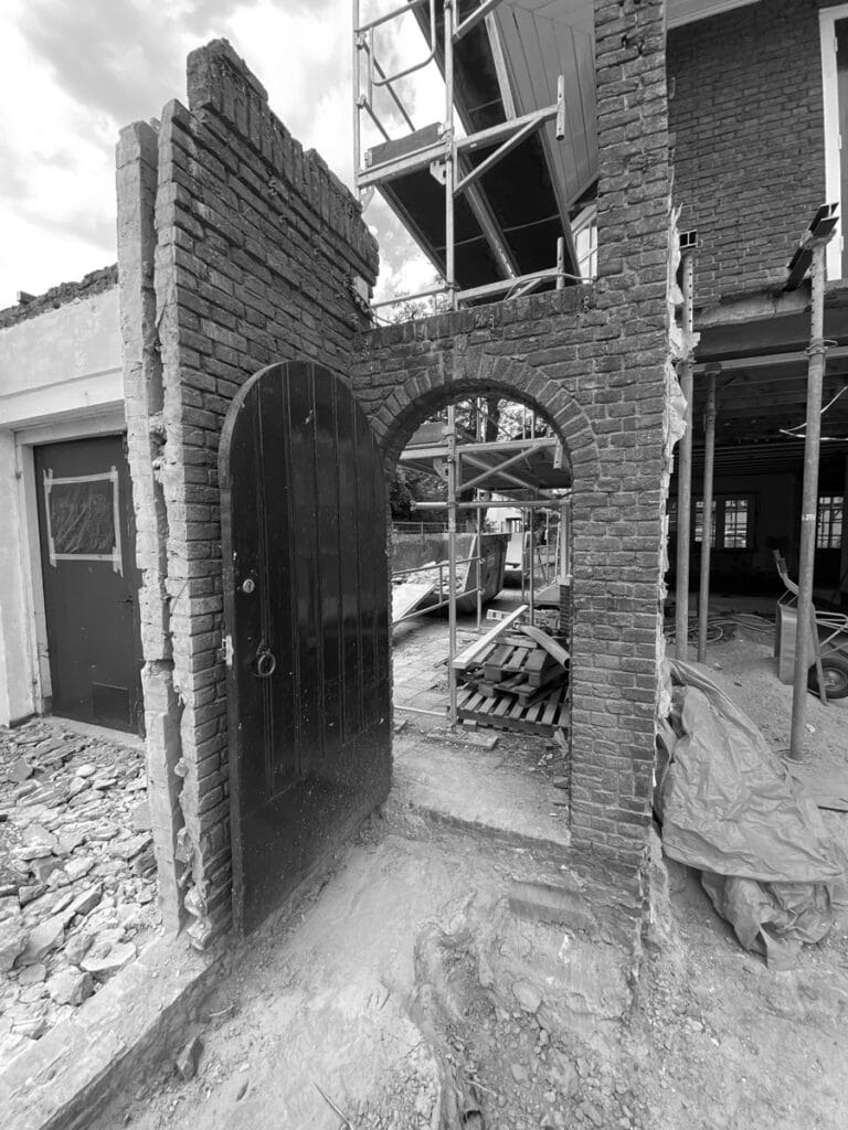 Deel afgebroken garagegevel: gemetselde toogdeur, behouden stadsgezichtswanden.