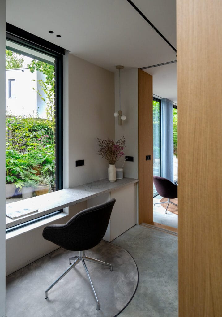 Interieur werkplek tuinkamer: bureau aan raam, direct tuin zicht, ensuite deuren voor besloten werken.