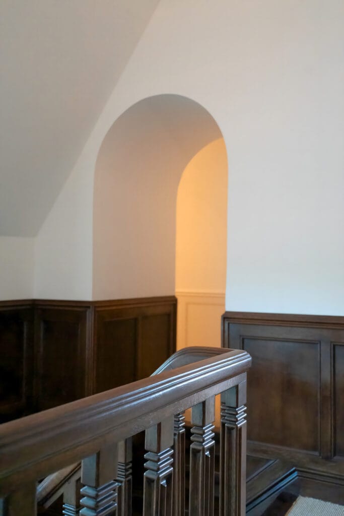 Detail trapleuning Karel de Bazel: geprofileerde spijlen, bordes met getoogde wandopening.